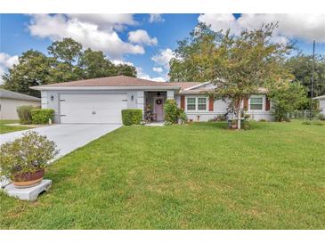 Charming single-story home featuring a well-manicured lawn and inviting curb appeal at 10086 Sw 62Nd Terrace Rd, Ocala, FL 34476
