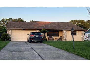 Charming single-story home featuring a well-maintained lawn and driveway with a two-car garage at 10885 Se 74Th Ct, Belleview, FL 34420