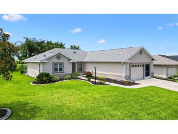 Well-maintained single Gathering home with a lush green lawn and manicured landscaping at 12178 Se 174Th Pl, Summerfield, FL 34491