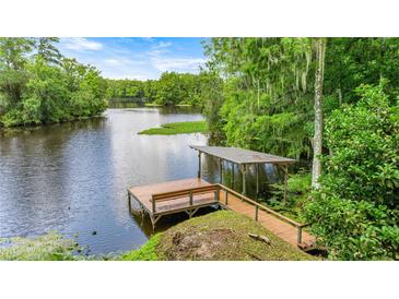 Picturesque dock with bench seating and covered area, overlooking the tranquil lake at 19620 Fox Trl, Dunnellon, FL 34432