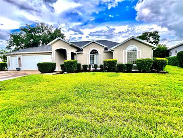 Charming single-story home featuring a well-manicured lawn and welcoming curb appeal at 2100 Nw 50Th Cir, Ocala, FL 34482