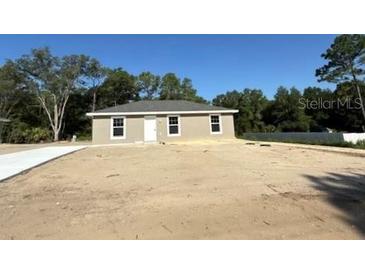 Charming single-story home with a well-maintained lawn and a paved driveway at 2350 Sw 150Th Ct, Ocala, FL 34481