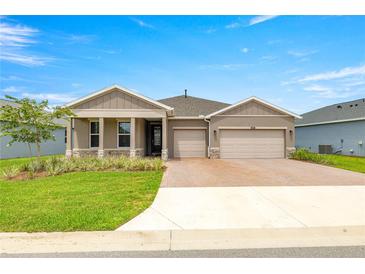 Charming single-story home featuring a well-manicured lawn and a two-car garage at 4474 Nw 53Rd Ave Rd, Ocala, FL 34480