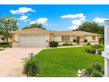 Charming single-story home with a well-manicured lawn, lovely landscaping, and attached two-car garage at 6172 Sw 101St Pl, Ocala, FL 34476