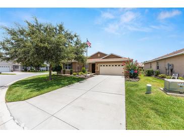 Charming home featuring a well-manicured lawn, mature trees, and an inviting driveway leading to the front entrance at 9222 Sw 97Th Cir, Ocala, FL 34481