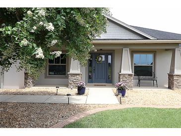 Charming home featuring a decorative front door, stone accents, and blooming landscaping at 1829 Nw 85Th Loop, Ocala, FL 34475