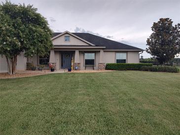 Charming home featuring a lush green lawn and manicured landscaping and craftsman architectural details at 1829 Nw 85Th Loop, Ocala, FL 34475