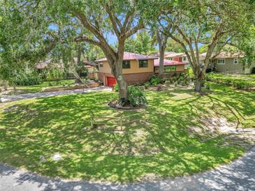 Charming home with a red roof, front yard, and mature trees offering shade at 2676 Se 52Nd Ave, Ocala, FL 34480