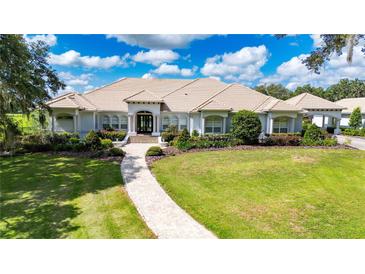 Stunning single-story home featuring a tile roof, lush landscaping and a brick walkway leading to the front entrance at 3440 Sw 66Th St, Ocala, FL 34476