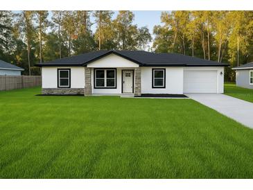Charming single-story home with a well-manicured lawn and neutral-tone exterior at 5 Laurel Pass Ln, Ocala, FL 34472