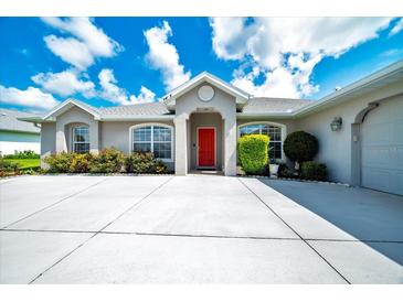 Charming single-story home with a well-manicured lawn and a welcoming red front door at 5459 Sw 86Th St, Ocala, FL 34476