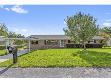 Charming single-story home with a well-manicured lawn, brick accents, and mature tree in the front yard at 713 Se 34Th Ter, Ocala, FL 34471
