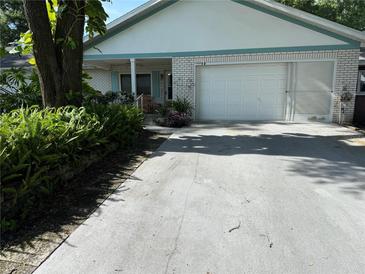 Charming single-story home featuring a light brick facade, attached garage, and well-maintained landscaping at 8874 Sw 95Th St # B, Ocala, FL 34481