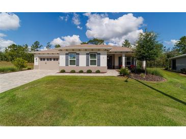 Charming one-story home with a well-manicured lawn, inviting curb appeal, and an attached two-car garage at 9746 Sw 108Th Terrace Rd, Ocala, FL 34481