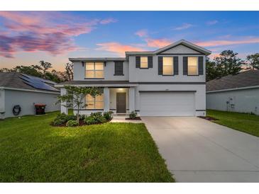 Charming two-story home featuring a well-manicured lawn and an attached two-car garage at 11205 Se 69Th Ter, Belleview, FL 34420