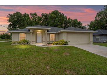 Charming single-story home with a well-manicured lawn, mature trees and neutral color palette at 14650 Sw 33Rd Ln, Ocala, FL 34481