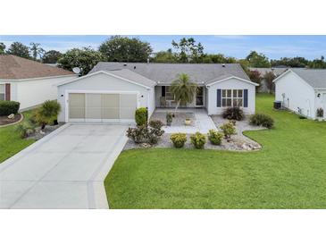 Charming single-story home features a well-manicured lawn and inviting landscaping at 1819 Captiva Ct, The Villages, FL 32162