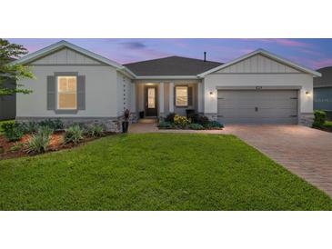 Charming single Gathering home with a well-manicured lawn and neutral exterior paint, accented by decorative stone elements at 4419 Nw 54Th Ter, Ocala, FL 34482