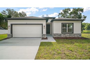 Charming single-story home featuring a two-car garage and stone accents on the facade at 5 Larch Course Ter, Ocala, FL 34480