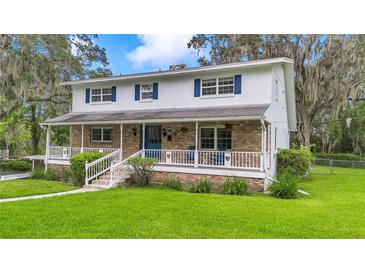 Charming two-story home featuring a brick facade, inviting front porch, and well-manicured lawn with mature trees at 510 Se 19Th St, Ocala, FL 34471