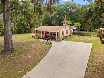 Quaint single-story home with a long driveway and ample space for parking at 581 Ne 44Th Ave, Ocala, FL 34470