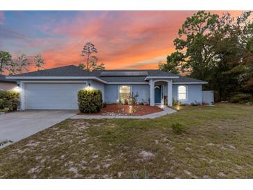 Charming single-story home with a well-maintained front yard and attached two car garage at 603 Marion Oaks Blvd, Ocala, FL 34473