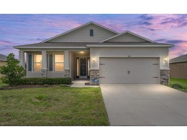 Charming single-story home with a two-car garage, well-maintained lawn, and stone accents at 6175 Sw 88Th Loop, Ocala, FL 34476