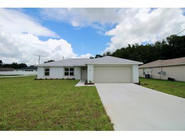 Charming single-story home with a well-manicured lawn and attached two car garage at 9 Hemlock Terrace Ln, Ocala, FL 34472