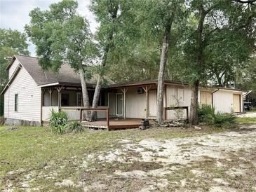 Charming single story home with a wooden deck and a large yard surrounded by mature trees at 25600 Se 152Nd Pl, Umatilla, FL 32784