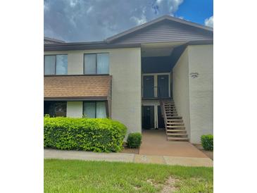 Inviting two-story condo with well-maintained landscaping and exterior stairs to the second floor units at 550 Fairways Dr # A, Ocala, FL 34472