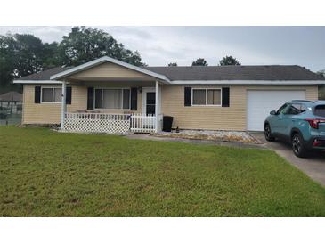 Charming ranch style home with a cozy front porch, one car garage, and well-manicured lawn at 8124 Sw 106Th St, Ocala, FL 34481