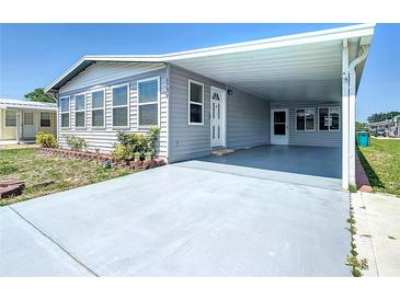 Charming single-story home with a covered carport and well-maintained landscaping, painted in neutral gray tones at 6739 Kensington Ne Dr, Winter Haven, FL 33881
