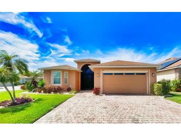 Beautiful single-story home featuring brick paved driveway and two-car garage with lovely tropical landscaping at 4577 Back Nine Dr, Winter Haven, FL 33884