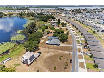 Expansive aerial view showcasing a lakeside home with solar panels and nearby community at 1396 Lucerne Loop Ne Rd, Winter Haven, FL 33881