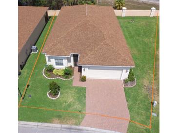 Charming single-story home with well-manicured lawn, brick driveway, and attached two-car garage at 2410 Salzburg Loop, Winter Haven, FL 33884