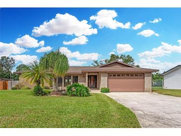 Brick ranch home with attached garage, landscaping, and a large yard at 524 Coleman W Dr, Winter Haven, FL 33884