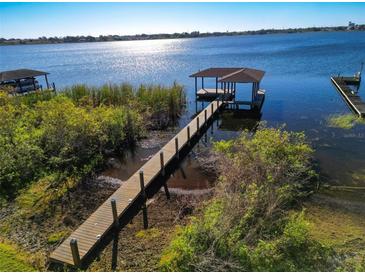 Picturesque view of a private boat dock extending into a tranquil lake with a covered pavilion at 4027 Island Lakes Dr, Winter Haven, FL 33881