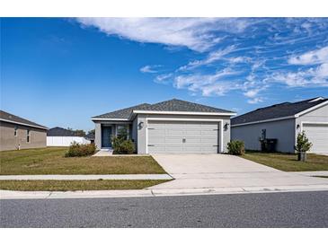 Single-story house with gray siding, two-car garage, and a well-maintained lawn at 4364 Reding Way, Lakeland, FL 33813
