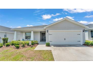 Charming single-story home with a well-manicured lawn, covered entry, and a two-car garage at 566 Valentina Ln, Auburndale, FL 33823