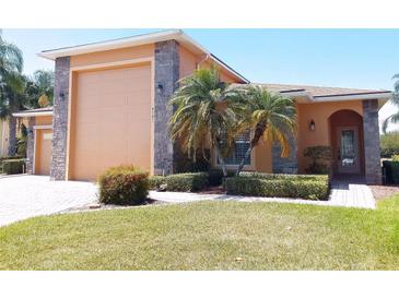 Charming single-story home featuring a stone-accented facade, well-manicured lawn, and mature palm trees at 4101 Limerick Dr, Lake Wales, FL 33859