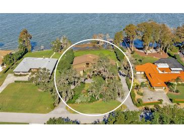 Aerial view of lakefront home with lush landscaping and spacious lot at 9 Skidmore Rd, Winter Haven, FL 33884