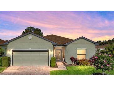 Well-maintained house with a landscaped front yard, neutral color scheme, and a two-car garage at 4076 Tralee Dr, Lake Wales, FL 33859
