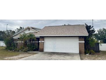 Brick house with attached garage, driveway, and landscaping at 6102 N Fork Ct, Lakeland, FL 33809