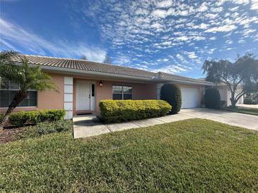 Tan house with white garage door and landscaping at 137 Harbor Way, Auburndale, FL 33823