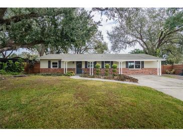 Ranch-style home with brick facade, landscaping, and driveway at 2104 John Arthur Way, Lakeland, FL 33803