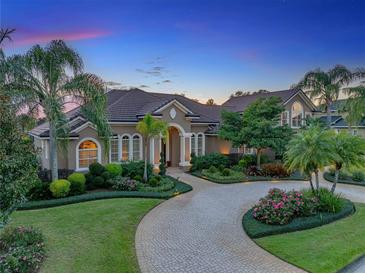 Stunning home exterior with circular driveway, lush landscaping, and elegant architectural details at 221 Mclean Pt, Winter Haven, FL 33884