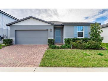 Gray one-story house with gray garage door and blue front door at 3285 Weitzel Dr, Haines City, FL 33844