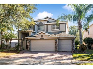 Two-story house with three-car garage and stone accents at 523 Brookeshire Dr, Davenport, FL 33837