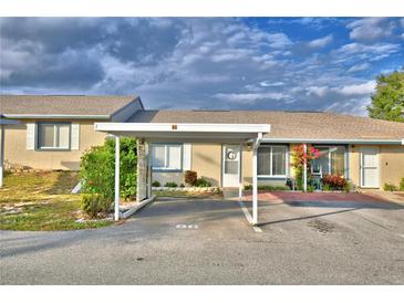 Tan house with carport and landscaping at 86 Winter Ridge Rd # 86, Winter Haven, FL 33881