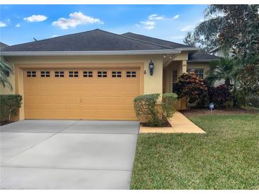 Charming single-story home featuring a well-maintained lawn, two-car garage, and colorful landscaping at 1068 Stoney Creek Dr, Lakeland, FL 33811